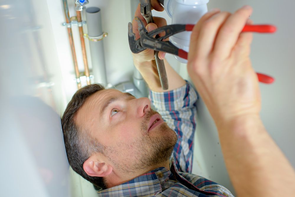 A man holding a pair of pliers in his hand.