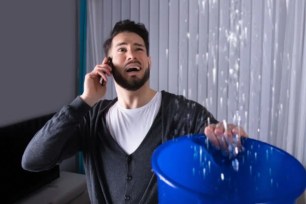 A man on the phone with a bucket of water.